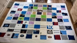 Verjaardagsquilt met blokken van kleding op witte ondergrond