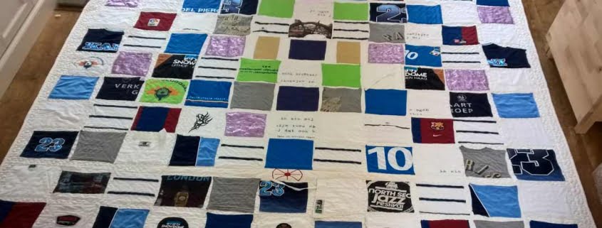 Verjaardagsquilt met blokken van kleding op witte ondergrond