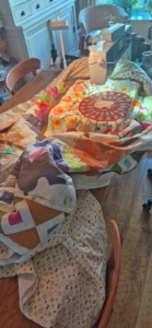 Grote quilt over tafel gedrapeerd bij de naaimachine