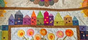 Rij doorgequilte huisjes in de Down the Rabbit Hole quilt